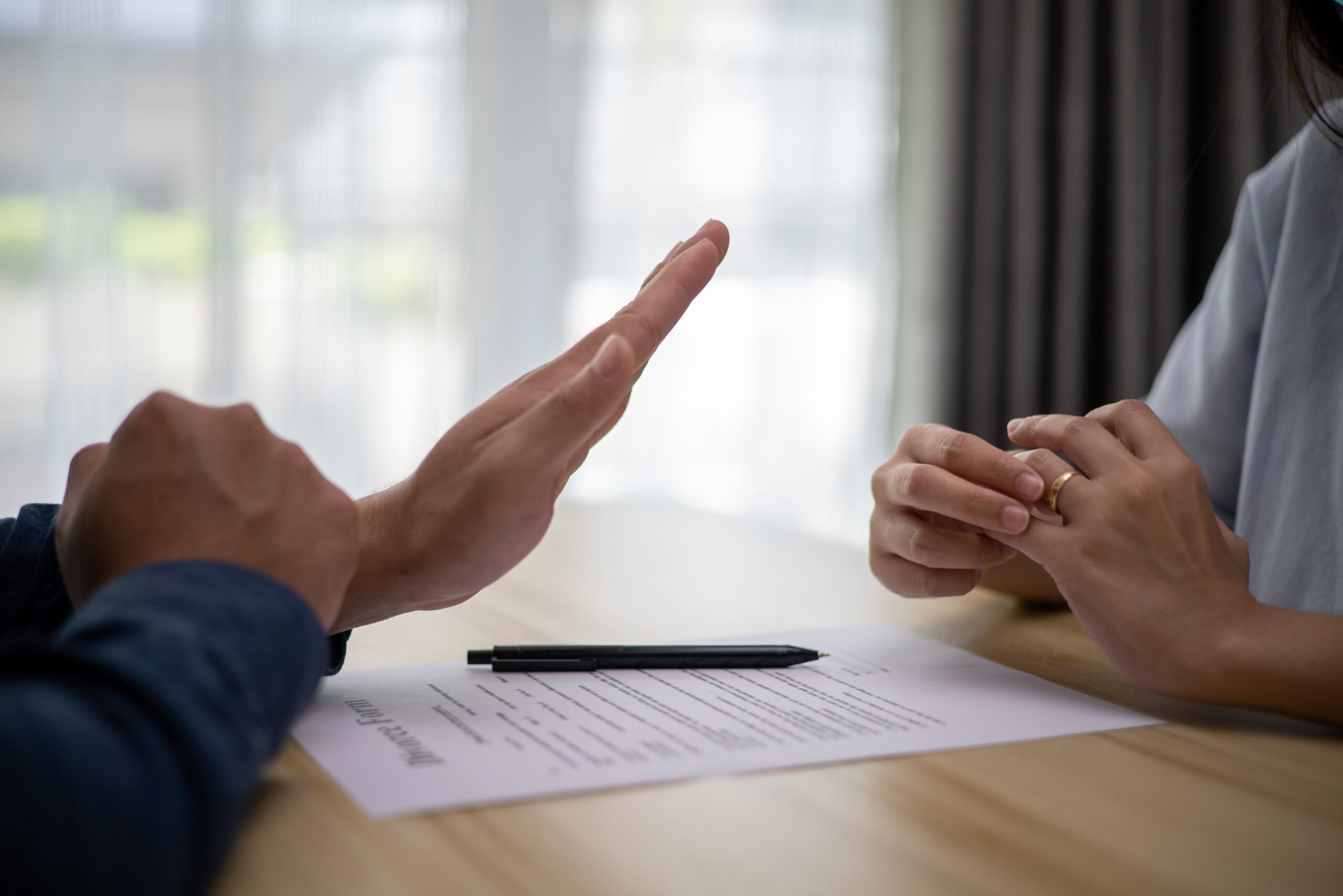 Woman divorcing and taking off wedding band. end of relationship, The hands of the wife and husband with the order of divorce. Divorce and separation concept.