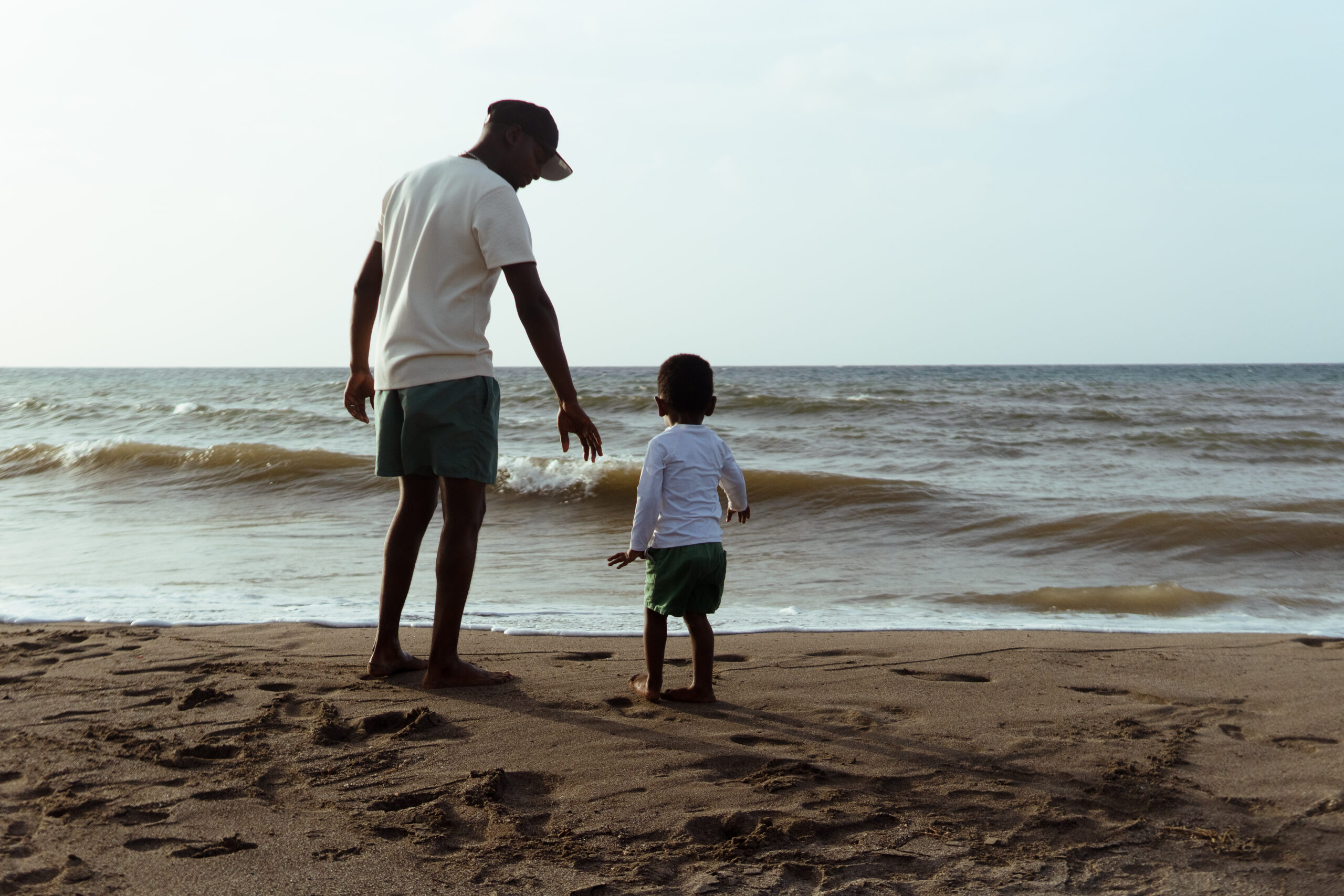 Father and son bonding on a sandy beach, enjoying the waves and creating lasting memories during their family vacation