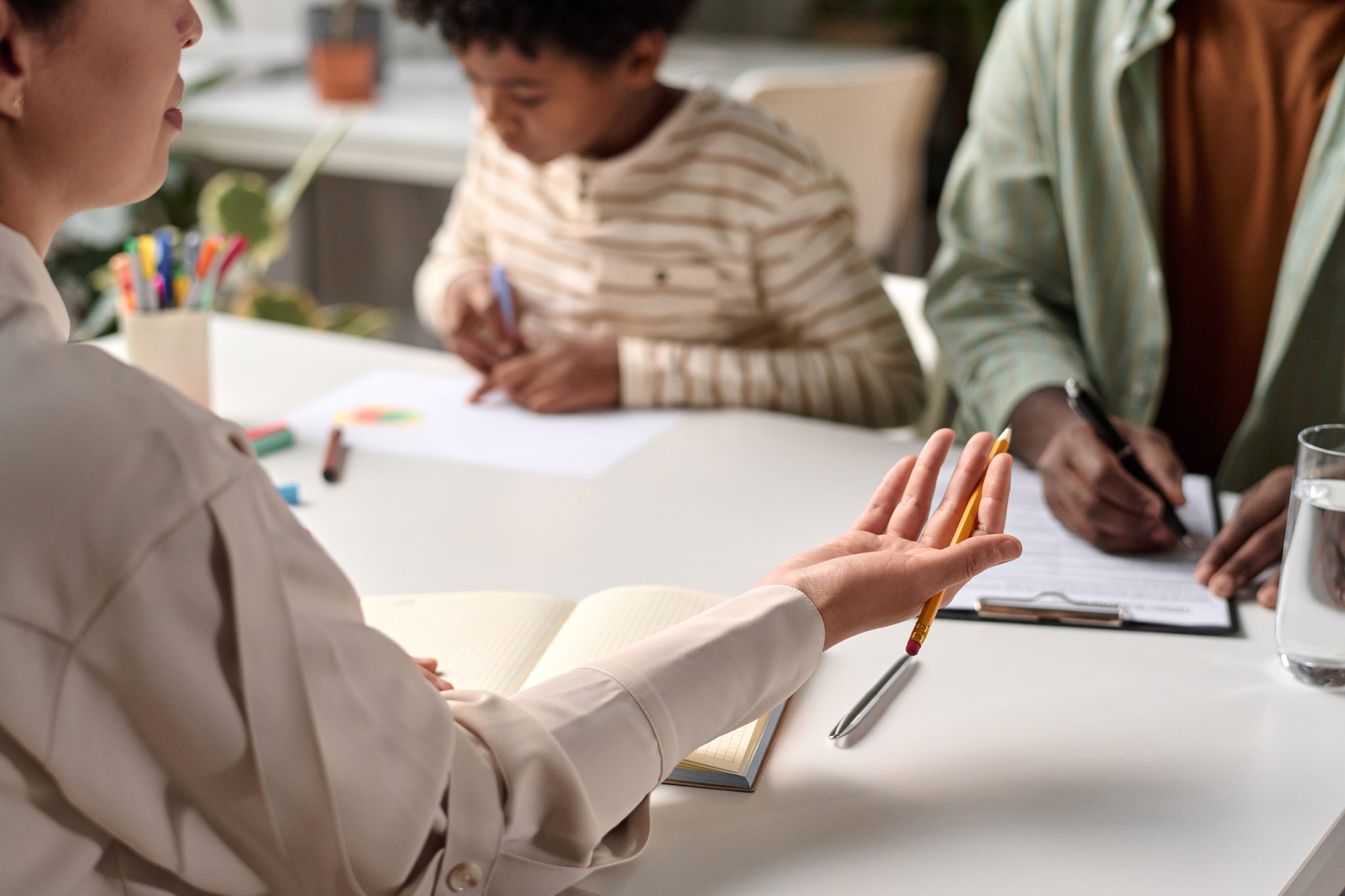 Close up of lawyer or social worker consulting African American family with focus on female hand gesturing, copy space