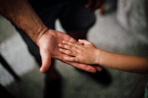 Child hand in parent hand representing child support obligations in Indiana family court