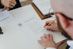 Person signing divorce paperwork in Indiana representing the divorce filing process