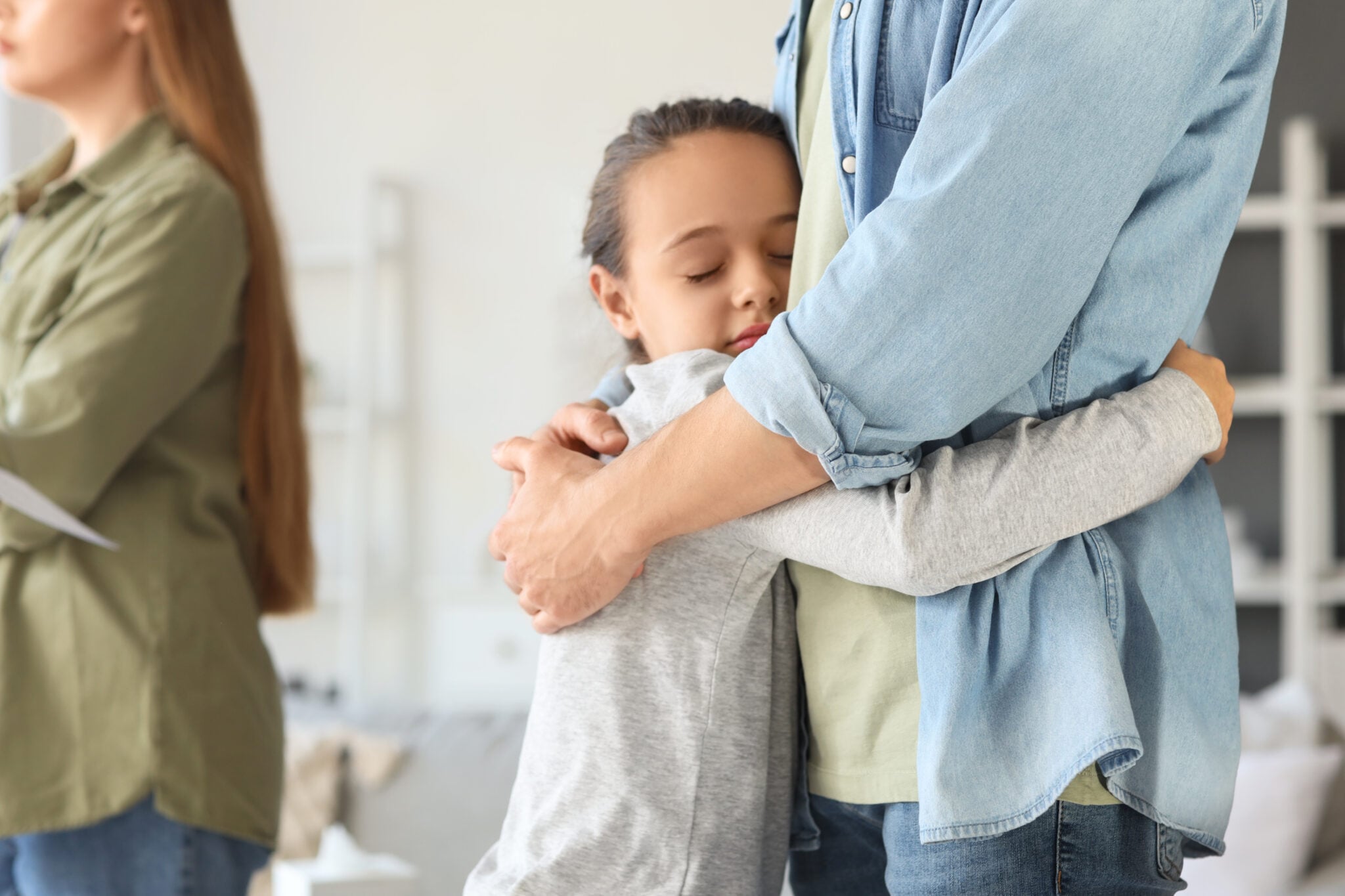 Little girl hugging her father after divorce at home