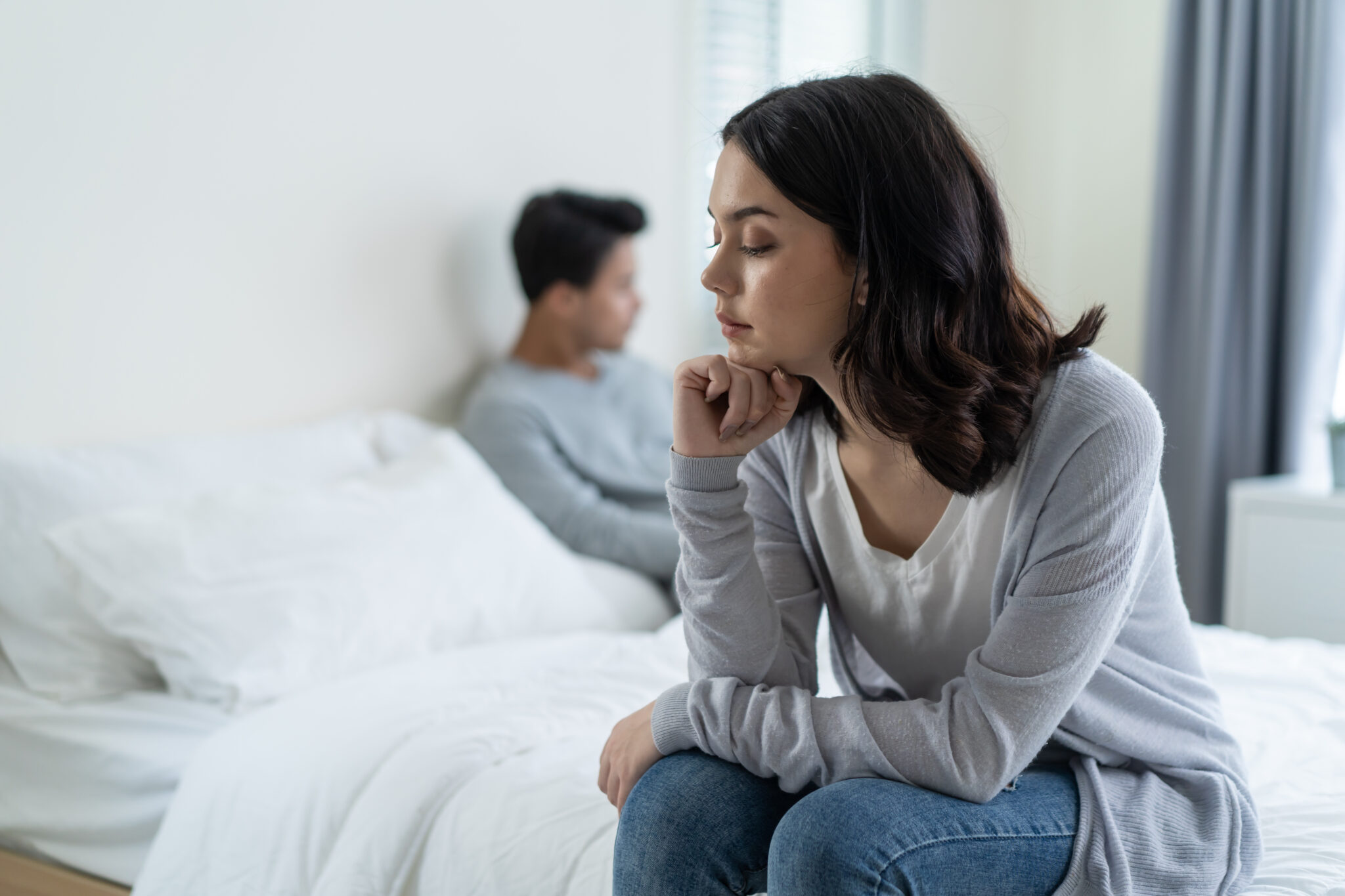 Asian young girl feel angry boyfriend having conflict domestic problem. New marriage man and woman feel heartbroken for quarrel conflict while sit on bed in bedroom. Family problem-separation concept.