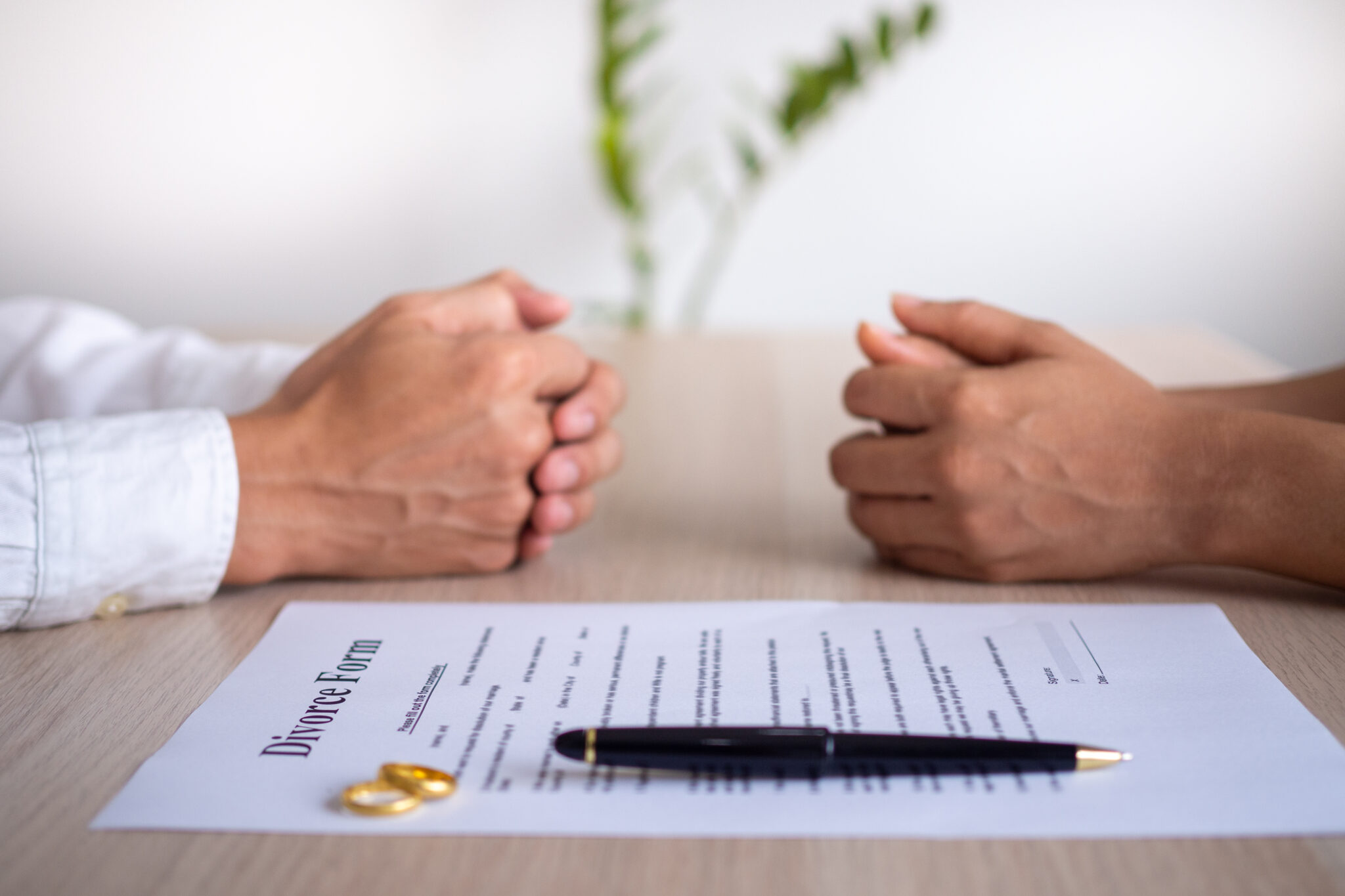 The hands of the wife and husband with the order of divorce, dissolution, cancellation of marriage, legal separation documents, divorce filings or pre-marital agreements prepared by a lawyer.