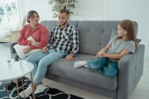 Parents and child seated on a sofa during a high-conflict custody discussion in Indiana