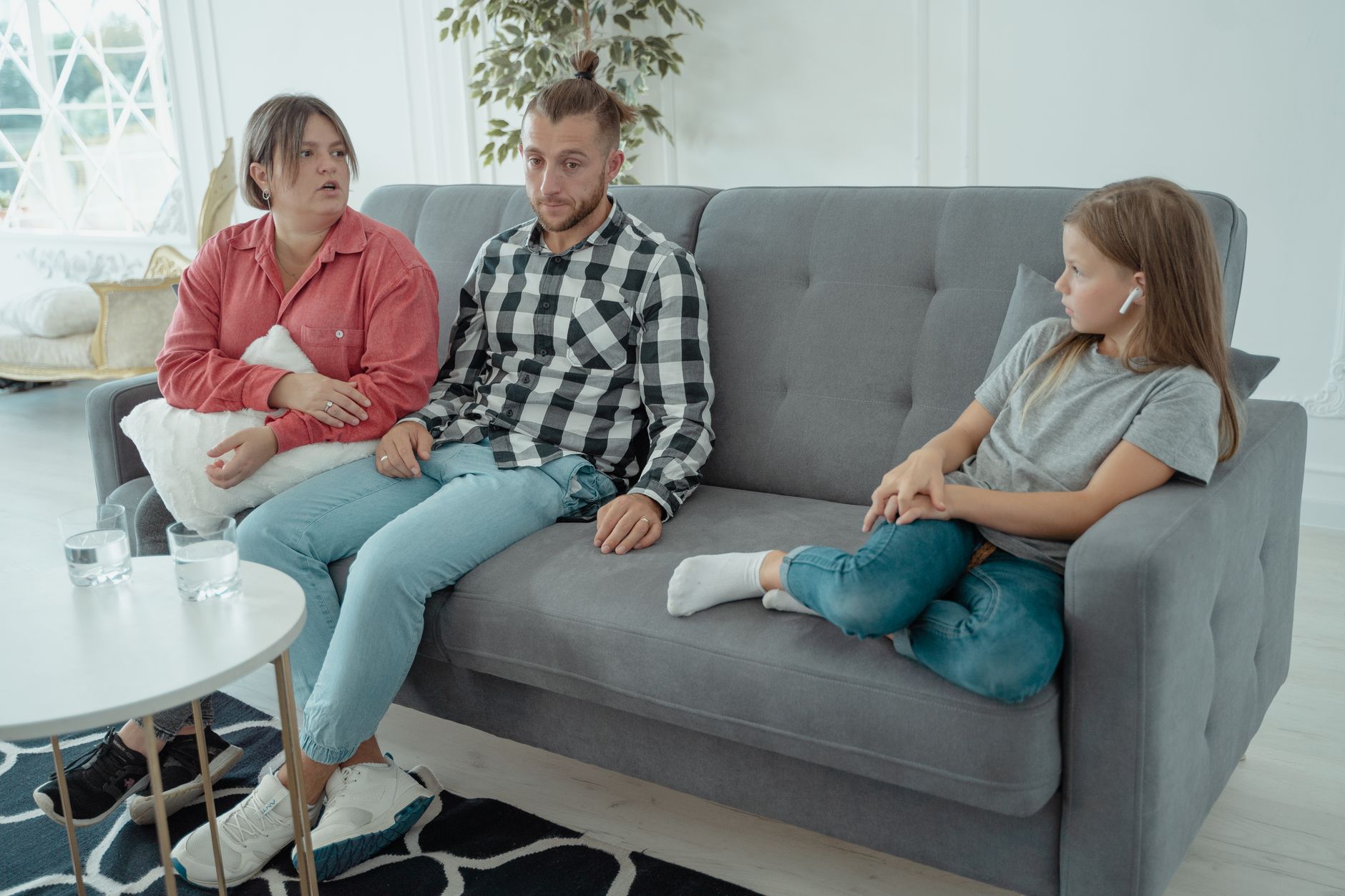 Parents and child seated on a sofa during a high-conflict custody discussion in Indiana